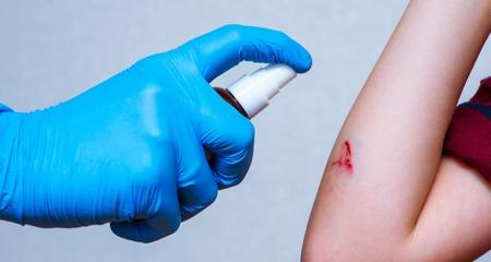 soignant en train d'appliquer un desinfectant antiseptique sur un enfant