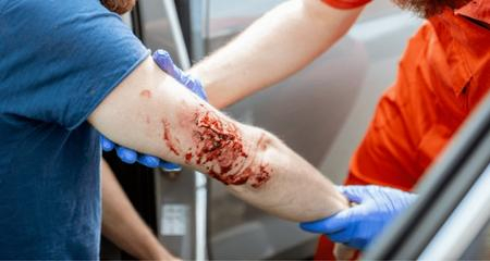 médecin en train d'arrêter un saignement sur un homme blessé